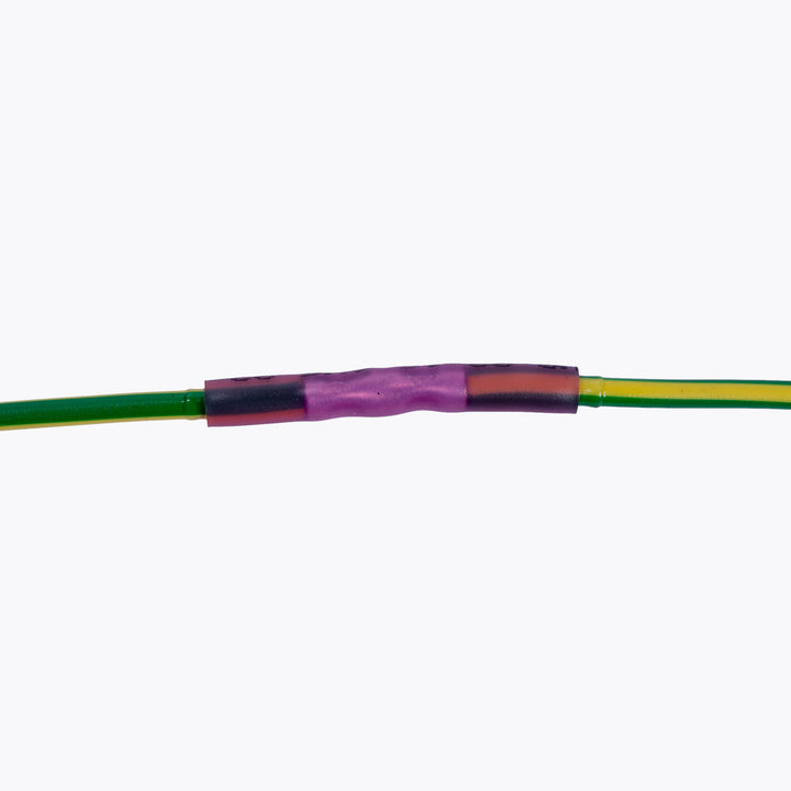 Close-up of an electrical connection using a Cable Joiner Butt Splice 3mm Red (5 Pack) linking two green and yellow wires, ideal for camping power and LED lighting solutions by Innovative 4x4.