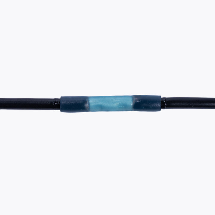 Close-up of a blue cable joiner butt splice connecting two black wires, demonstrating a secure electrical connection for camping power and LED lighting solutions with Cable Joiner Butt Splice 4mm Blue (5 Pack) by Innovative 4x4.